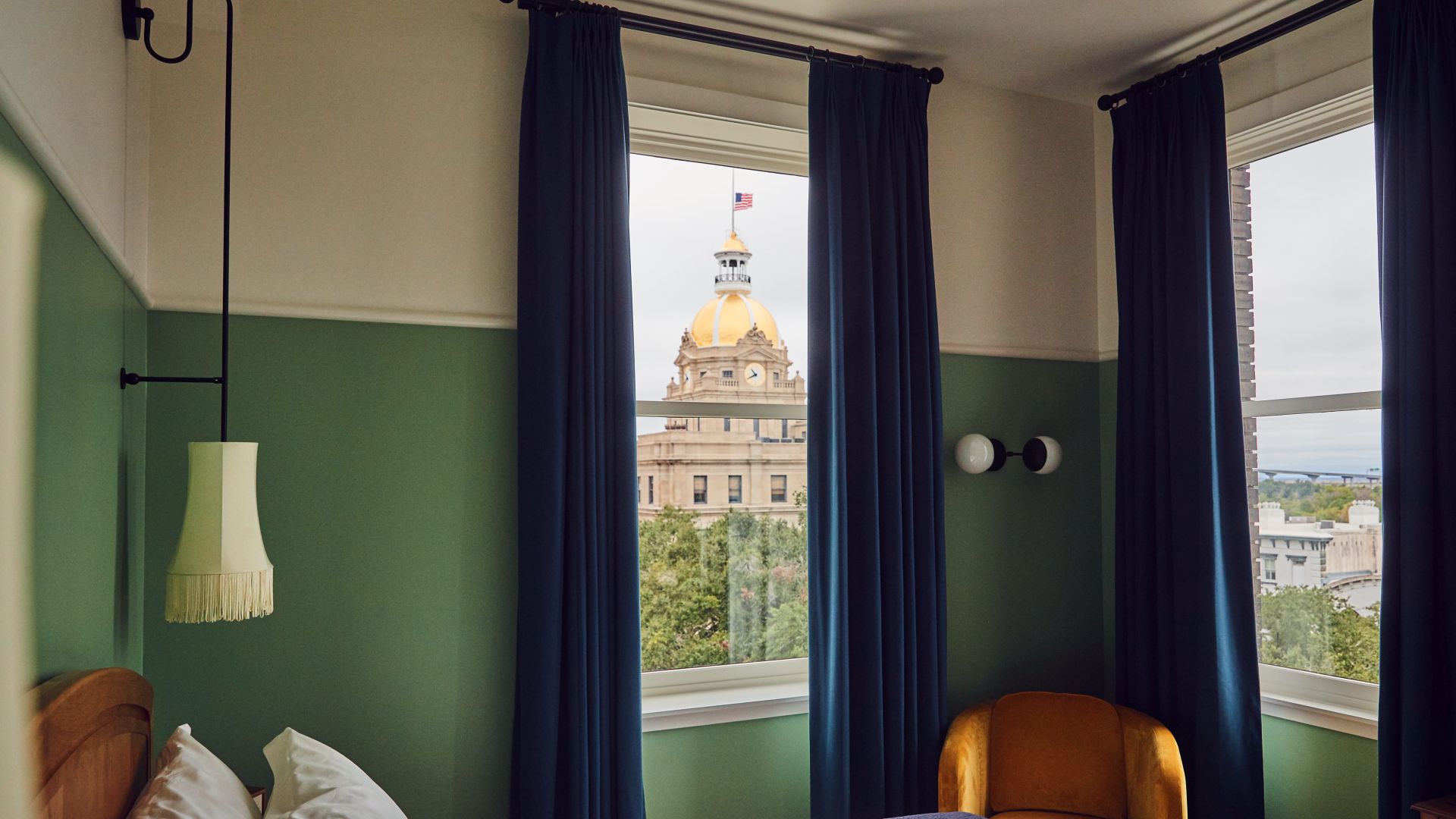 A Hotel Room With A Bed And A Large Window
